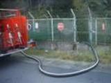 防火水槽から給水するポンプ車の写真